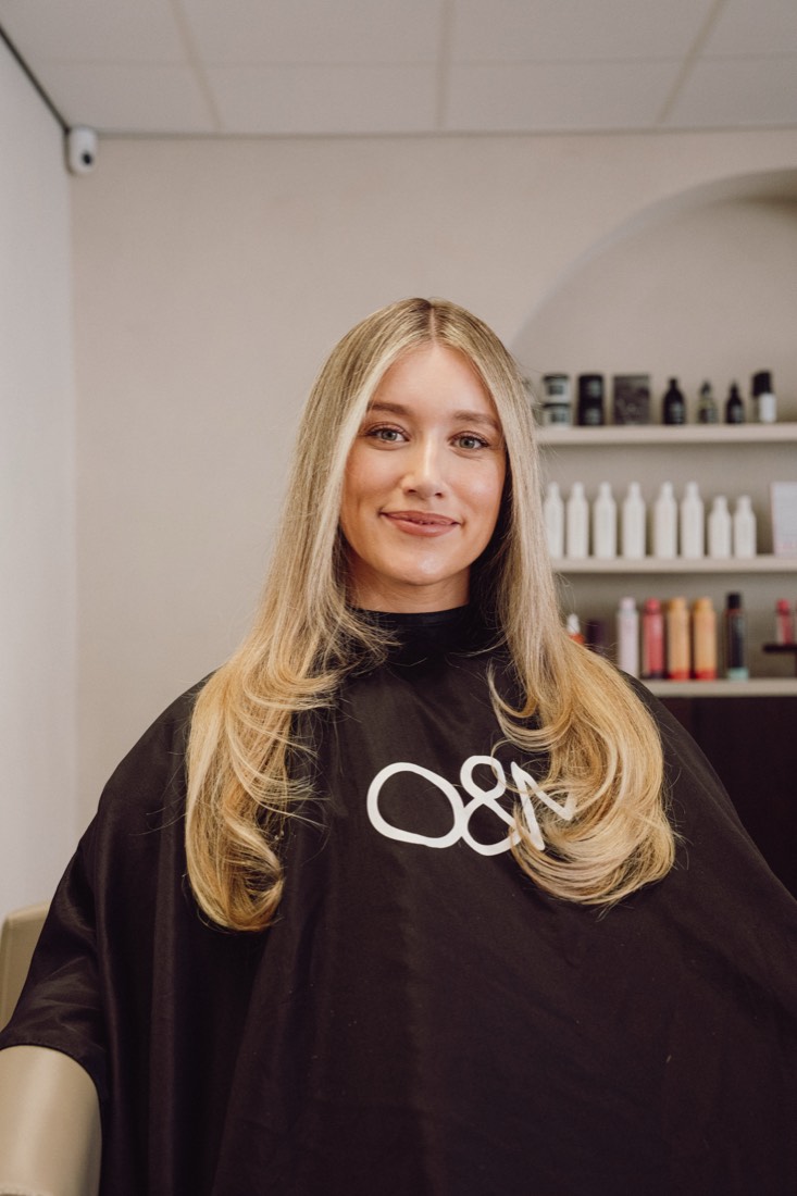 Klant met lang, zacht lived-in blond haar in de salon